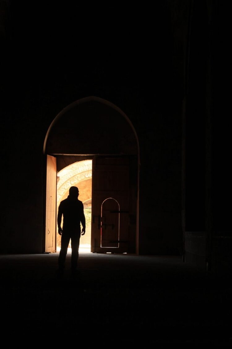 a silhouette of a man at the entrance of a building